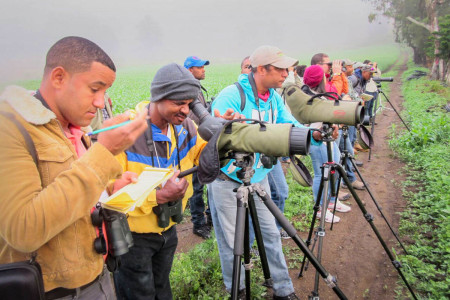 Participants practicing how to use spotting scopes to identify distant birds. (Photo by Beny Wilson)