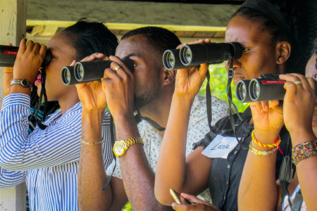 Teachers train their binoculars, looking from the verandah of Seville Great House.