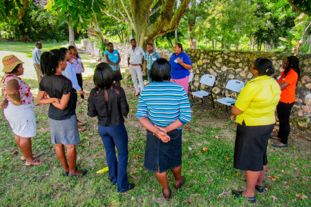 In the shade of the ackee tree, Ava Tomlinson explains aspects of bird migration to the group.