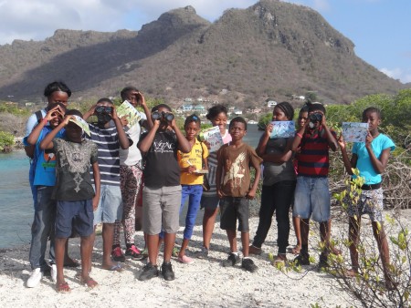 Students from the Mary Hutchinson Primary School and the Stephanie Primary School having fun with binoculars during a bird-watching session on Union Island with Sustainable Grenadines, Inc. (Photo by Orisha Joseph)
