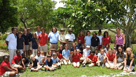 Members of the Eco Gardening Team (standing) with Mr. Suarez receiving sign by Erika and Marilyn on behalf of the National Wildlife Federation. Sitting in front are the LIS Birding students with Ms. Krupica.