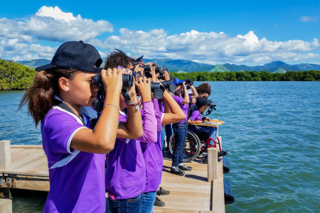 Students from the Jose Horacio Cora School, Arroyo, Puerto Rico, were delighted to learn how to use binoculars to spot Magnificent Frigatebirds, Royal Terns, and Osprey feeding in the waters at the Jobos Bay National Estuarine Research Reserve. (Photo by Ernesto Olivares)