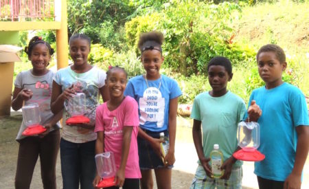 Students from Bagatelle Primary School, Dominica, with bird feeders and nectar after Hurricane Maria devastated this country and others in 2017.