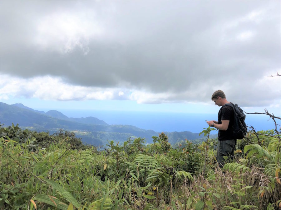 Adam Brown takes a GPS measurement on a ridge overlooking a valley where radar detected petrel movements in and out of the nearby peaks