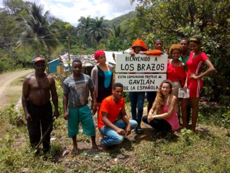 Members of the community of Los Brazos create a home-made sign that reads "Welcome to Los Brazos. This community protects the Ridgway's Hawk" to show their support of the conservation project