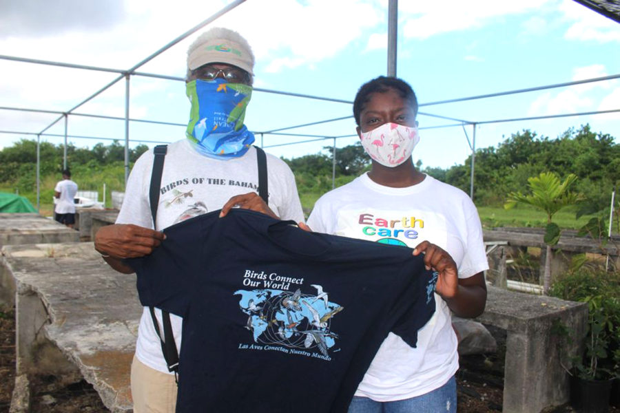 Bridget Davis receives World Migratory Bird Day shirt from EARTHCARE Eco Kids Team Leader, Shakada Hutson