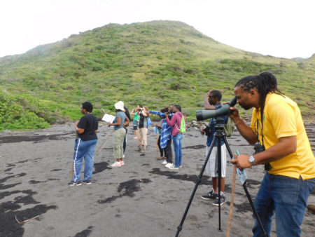 Minister of Agriculture looking at shorebirds in the spotting scope. 