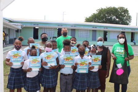 Grade 4 students at Pares Primary School, Antigua, take a photo with their new Into The Wild Booklets.