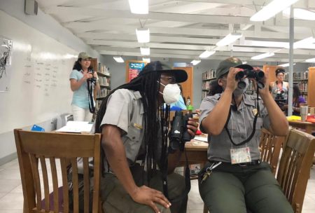 National Park Service staff practice using binoculars.