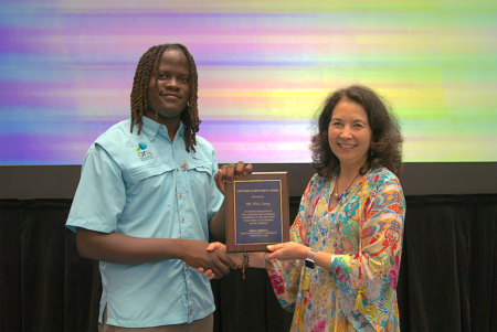 Elijah Sands accepts the BirdsCaribbean Lifetime Achievement Award on behalf of Mr. Eric Carey.