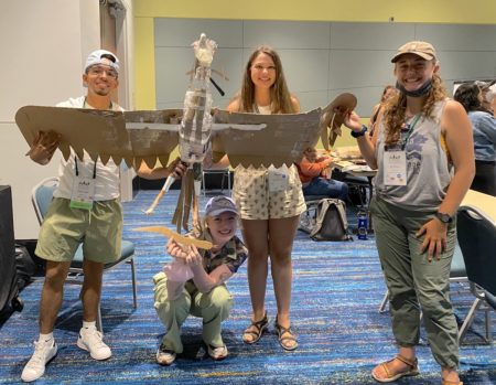 Participants in the Raptors of the Caribbean Workshop show off their bird of prey, made from recycled materials.