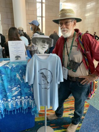 Jose Colon stands next to his Silent Auction donation – a vintage Society of Caribbean Ornithology T-shirt.