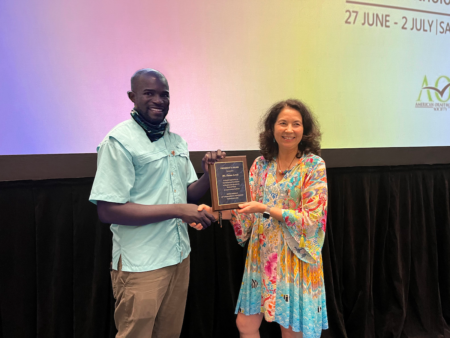 Ricardo Miller accepts BirdsCaribbean President's Award on behalf of Emma Lewis.