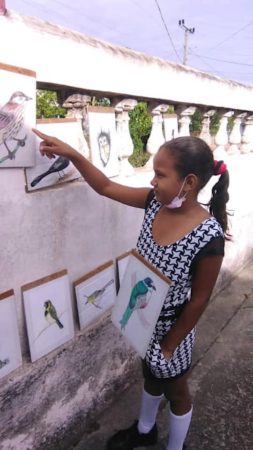 A student shows off bird illustrations during the CEBF festivities, Cuba.