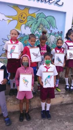 Students take a group photo holding their bird drawings during the CEBF festivities, Cuba.
