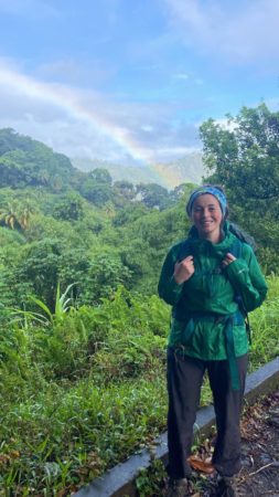 Kaitlyn on the Coffee Trail with a rainbow in the background.