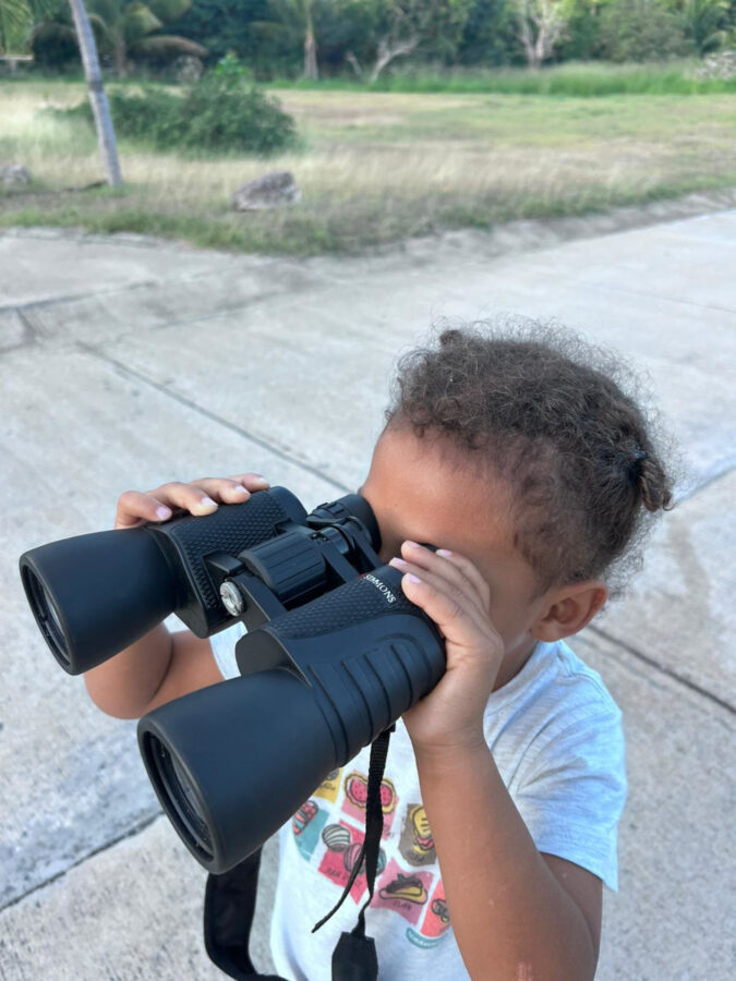 Small child looks through binoculars