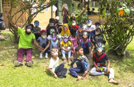 Group of adults and children wearing paper bird masks