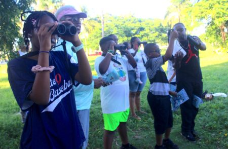 Children birdwatching during EARTHCARE's WMBD event at Princess Park, Grand Bahama.