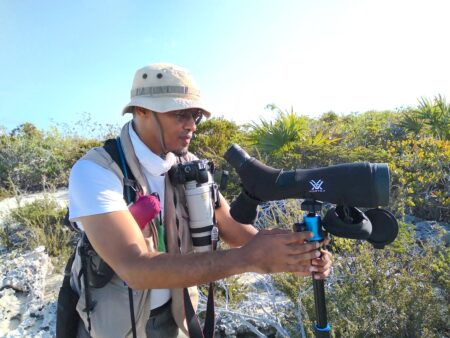 Photof of a man adjusting a spotting scope.