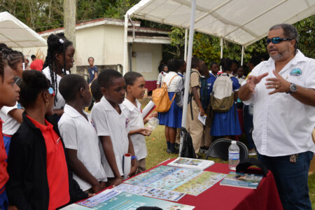 Group of school kids look at out reach materials
