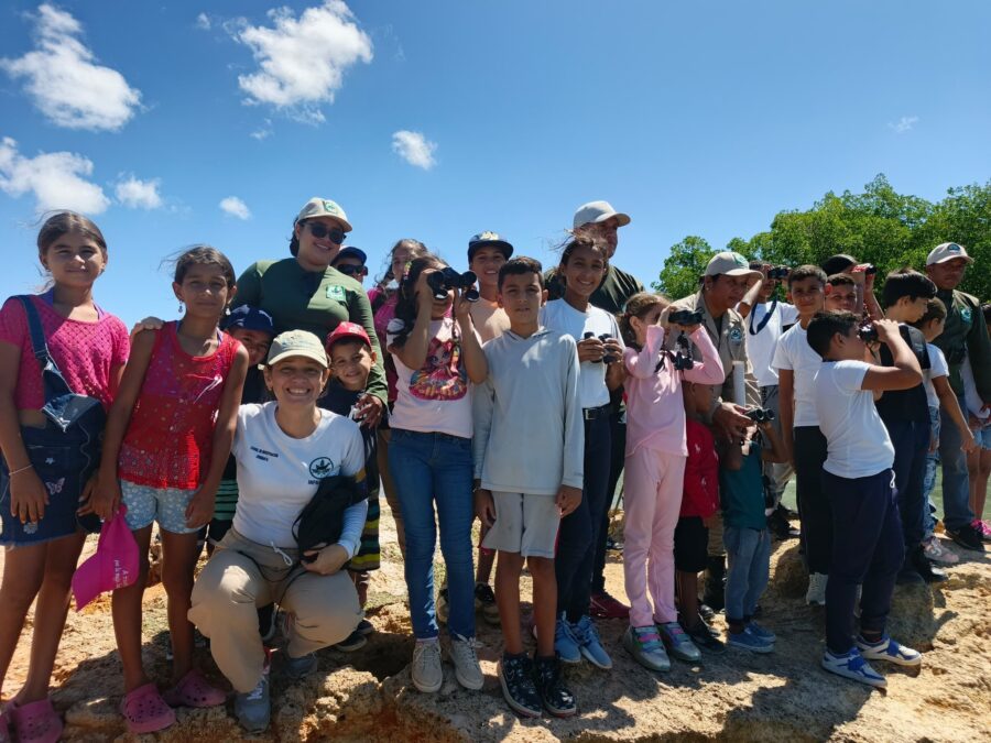 Group photo of adults and children outdoor. 
