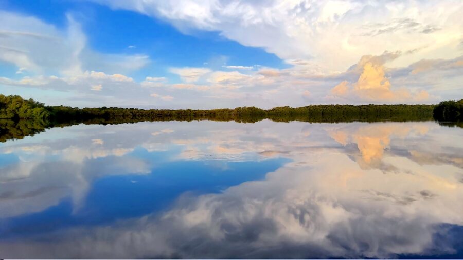 Photo of a lagoon in Cuba with the sky mirrored on the surface of the calm water.
