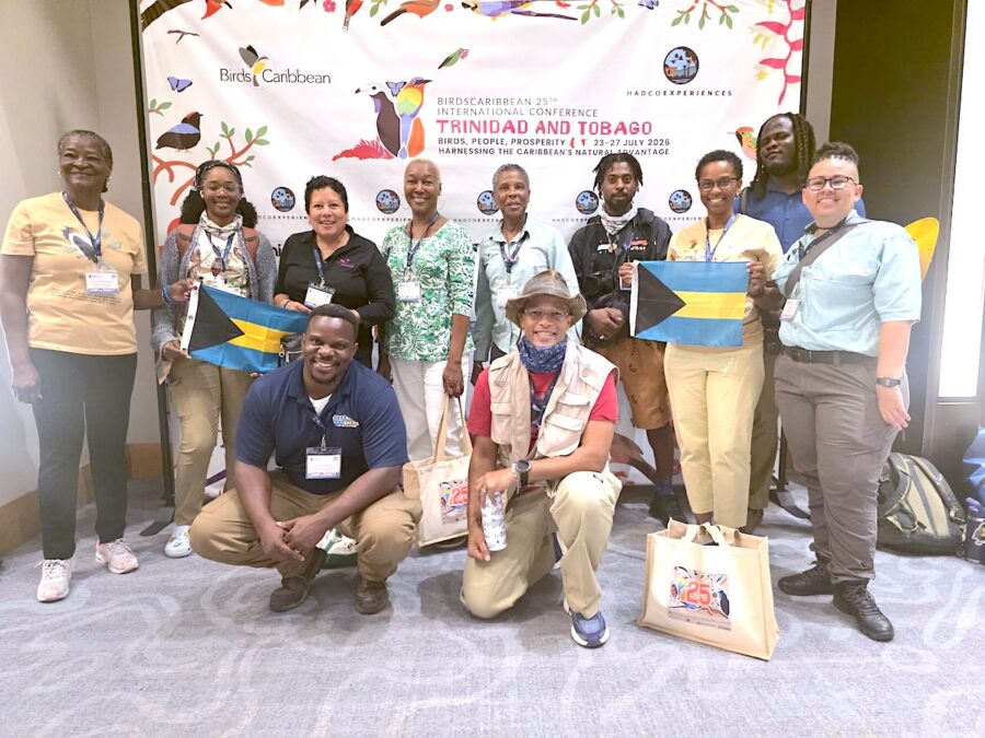 Group photo of Bahamians in front of the conference media backdrop
